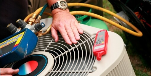 A technician servicing an ourdoor Air Conditioning unit