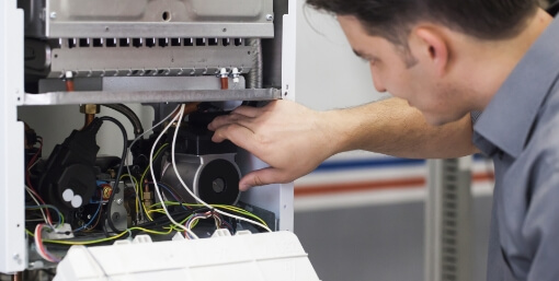 A technician working on a heating unit