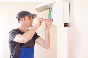 Air conditioner technician servicing indoor unit.